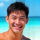 Chen Wei smiling on a beach
