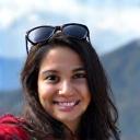 Priya Sharma smiling in front of a mountain landscape